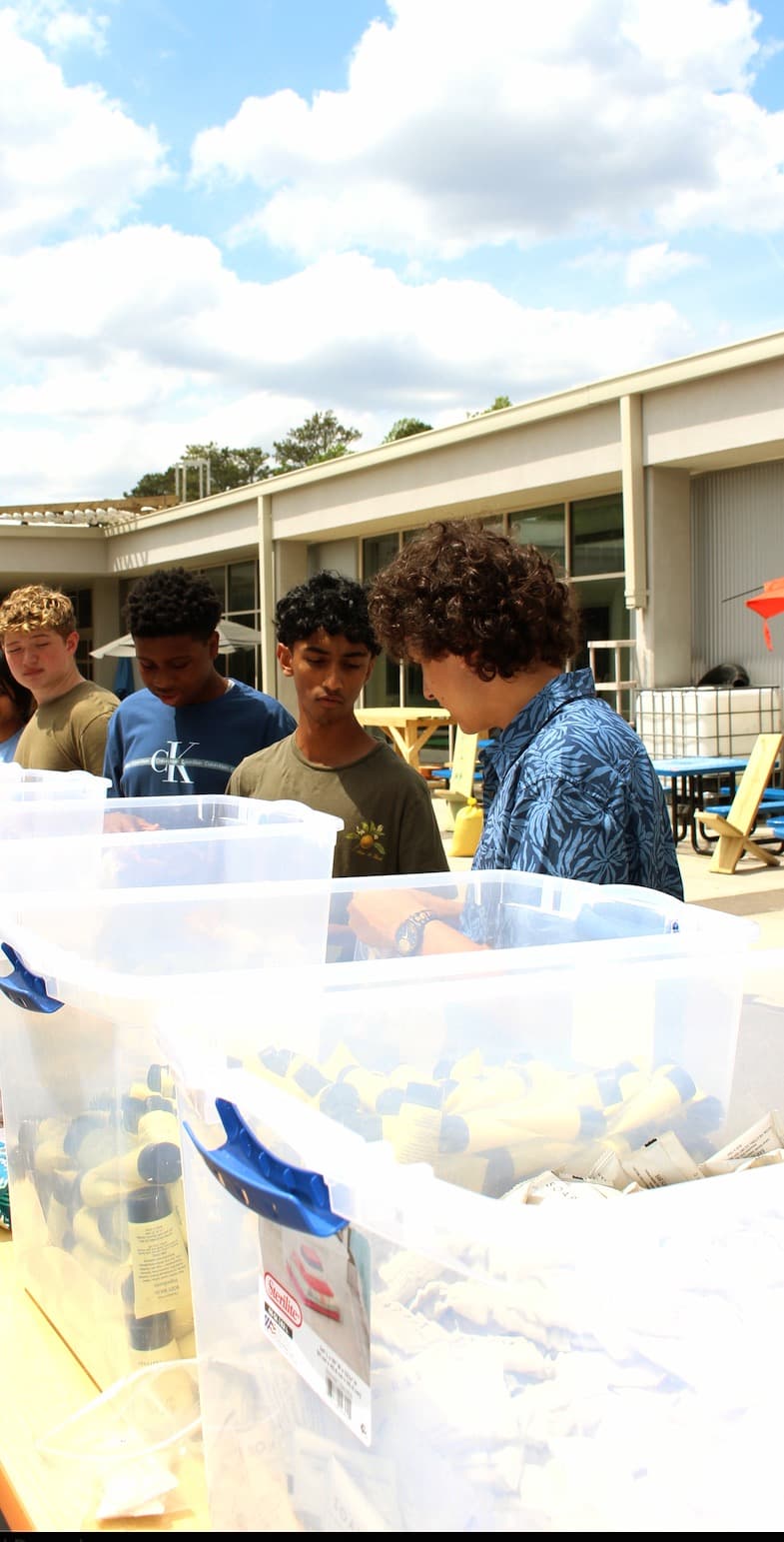 Group of Hands of Hope volunteers behind organized supply bins
