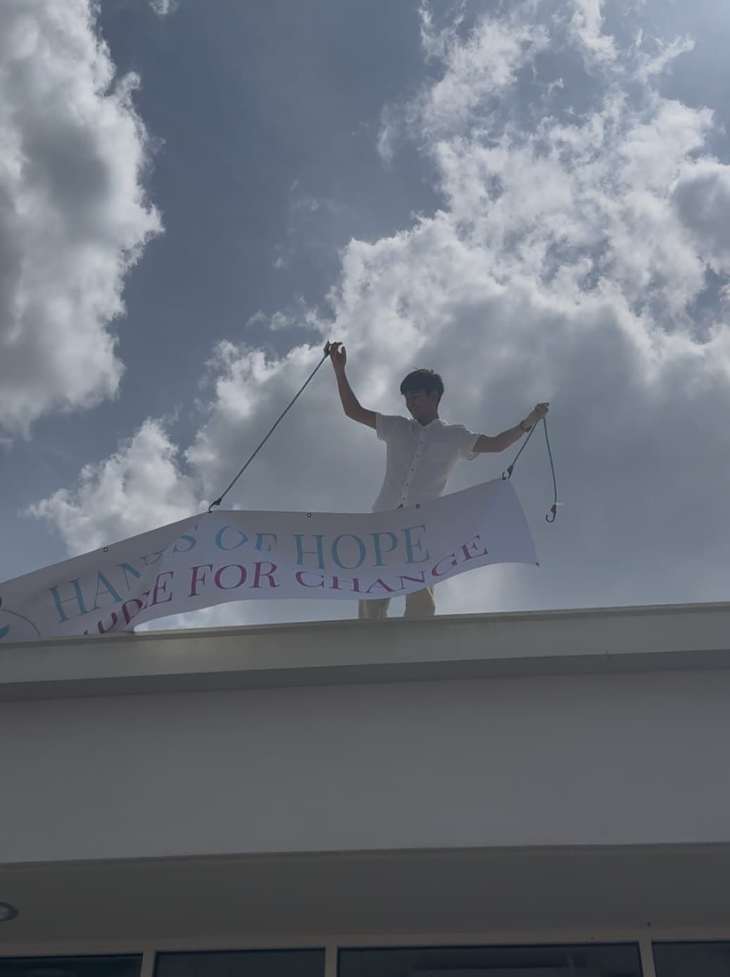 A Hands of Hope student raising the Ripple for Change banner above the venue